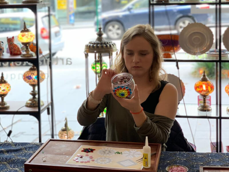 Woman with half finished Turkish mosaic lamp creating the other half